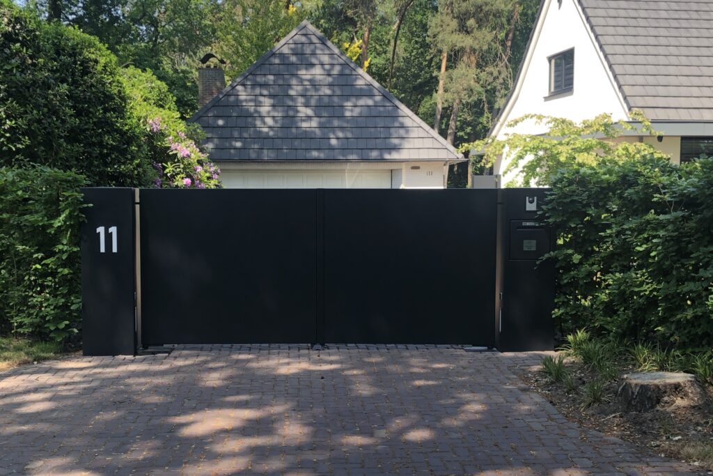 Een dichte schuifpoort voor veel privacy, Strak afgewerkt, stalen kolommen met verlicht huisnummer.