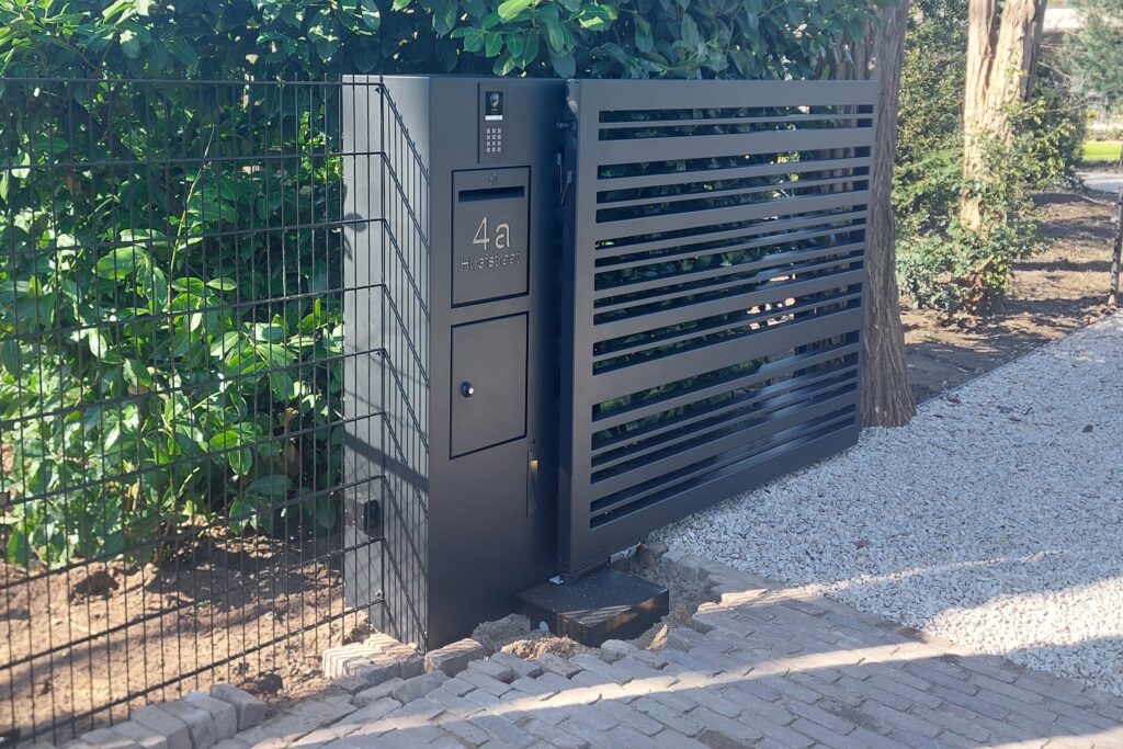 Stalen poort met stalen kolom. Hierin is de pakketbos en brievenbus, huisnummer , intercom en verlichting strak in verwerkt.