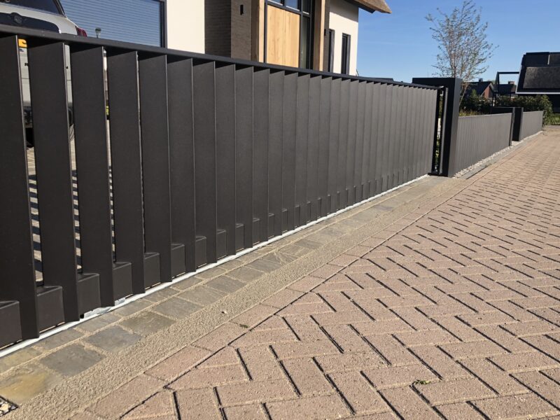 http://Moderne%20strakke%20schuifpoort%20van%20brede%20schuine%20lamellen.%20Passend%20bij%20een%20strakke%20tuin%20en%20moderne%20woning.