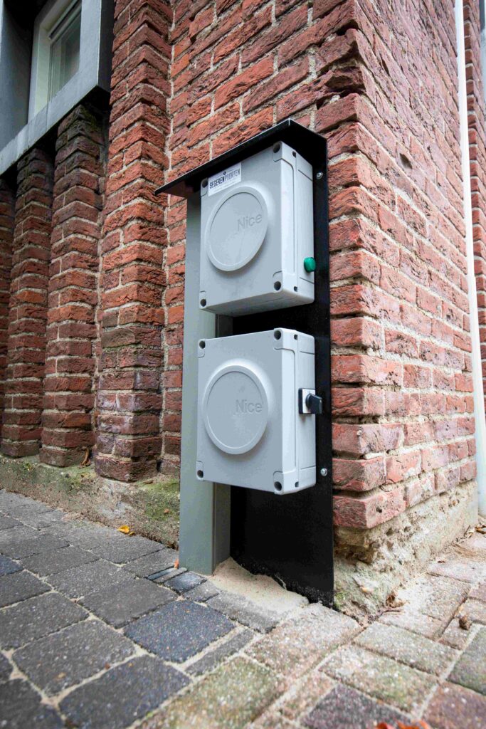 De besturing van de poortmotor komt tegen een montageplaat in de buurt van de poort, zodat deze droog hangt.